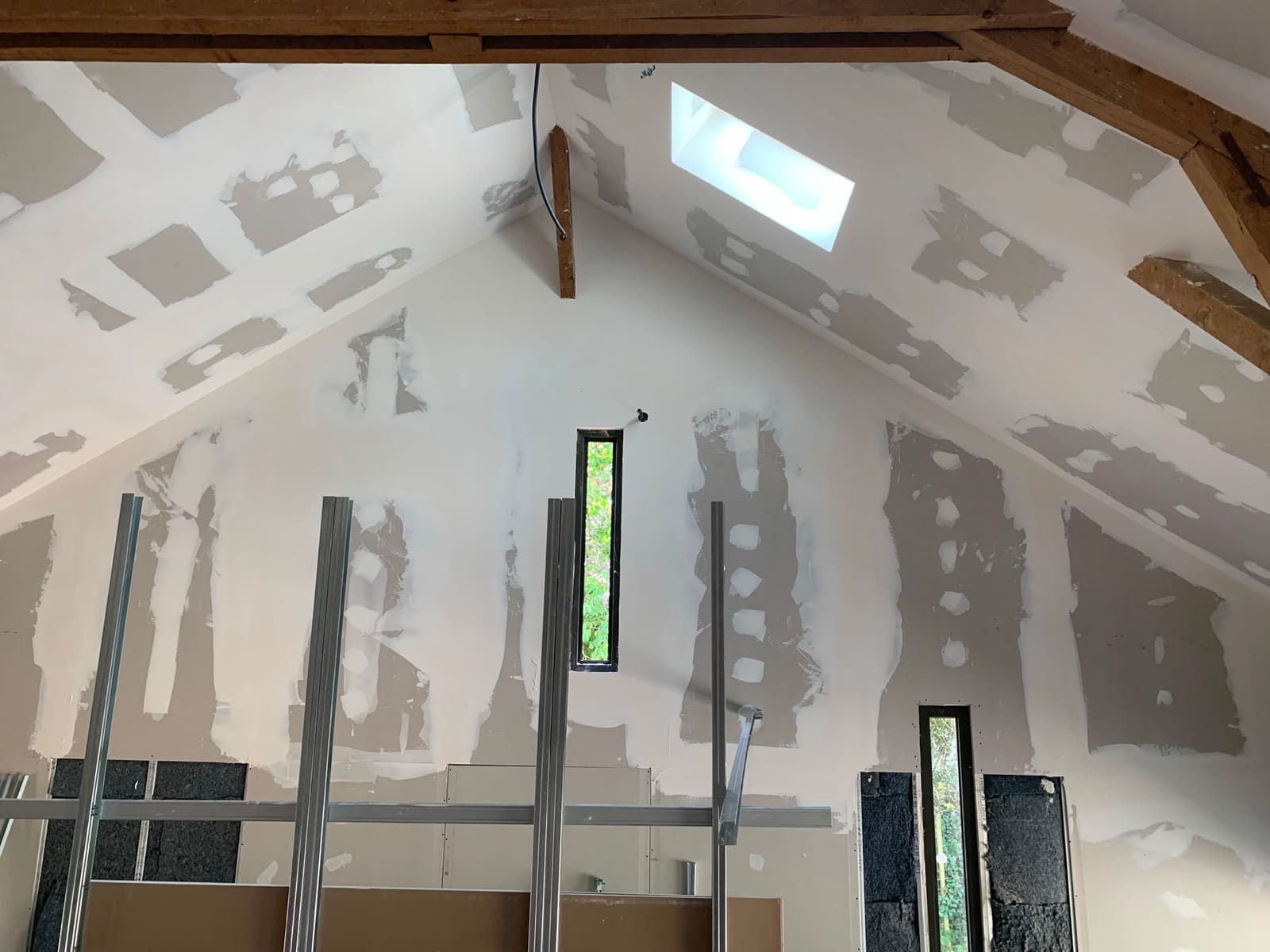 Aménagement de combles en plaques de plâtre avec bandes à joints et charpente apparente