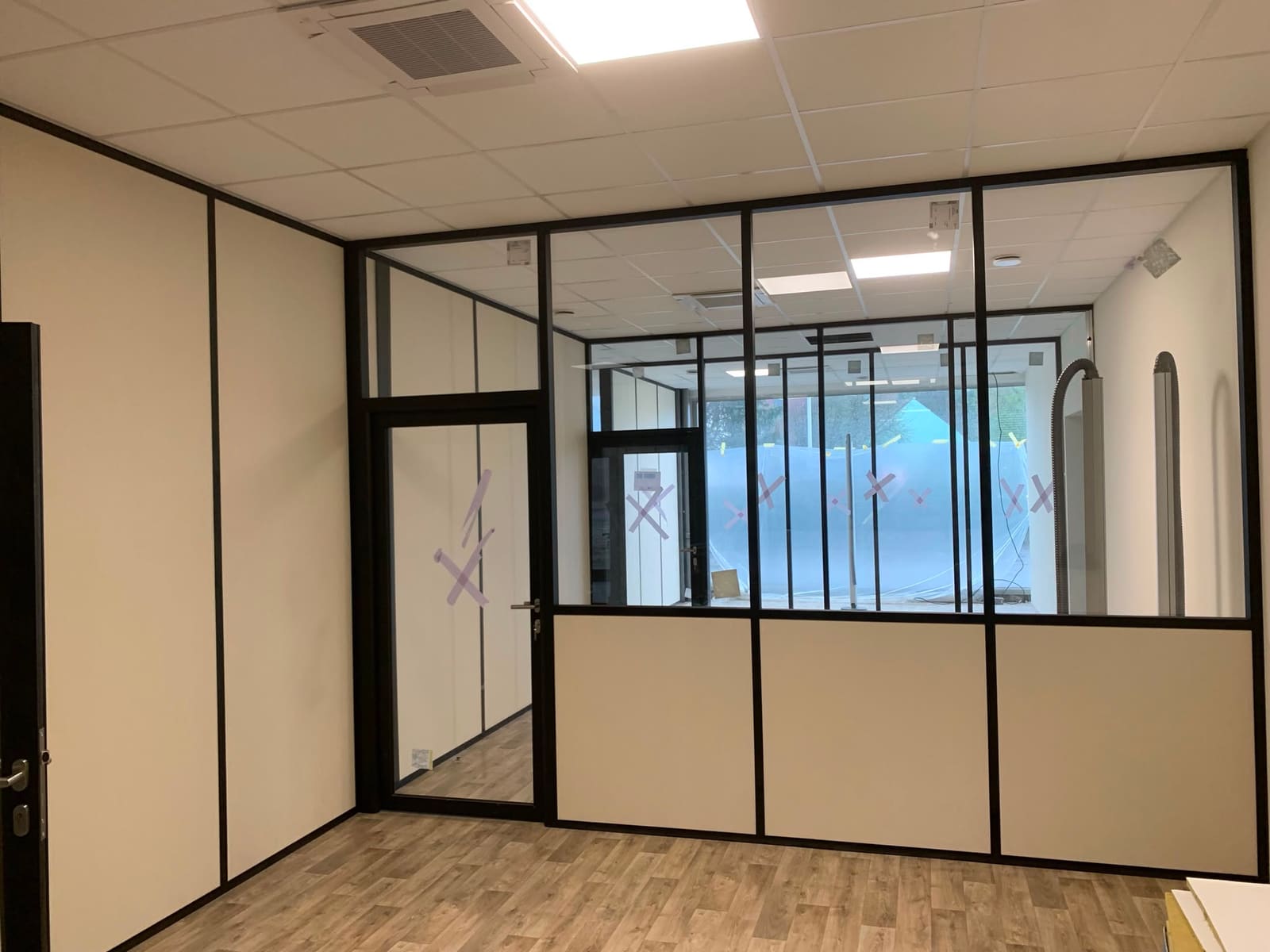 Cloisons amovibles vitrées séparant deux espaces de bureaux