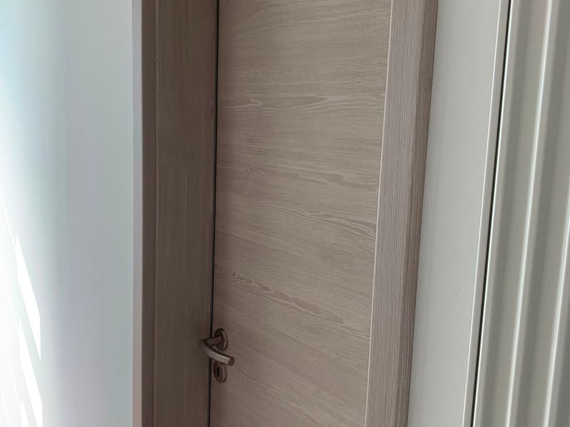 Porte intérieure en chêne clair avec huisserie et chambranle assortis, poignée métal