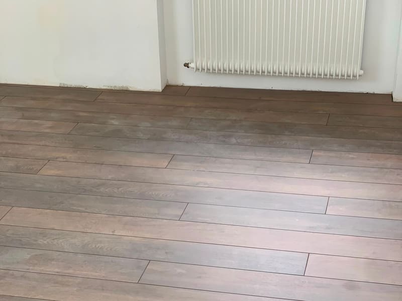 Sol en lames larges imitation chêne grisé posé dans une pièce rénovée